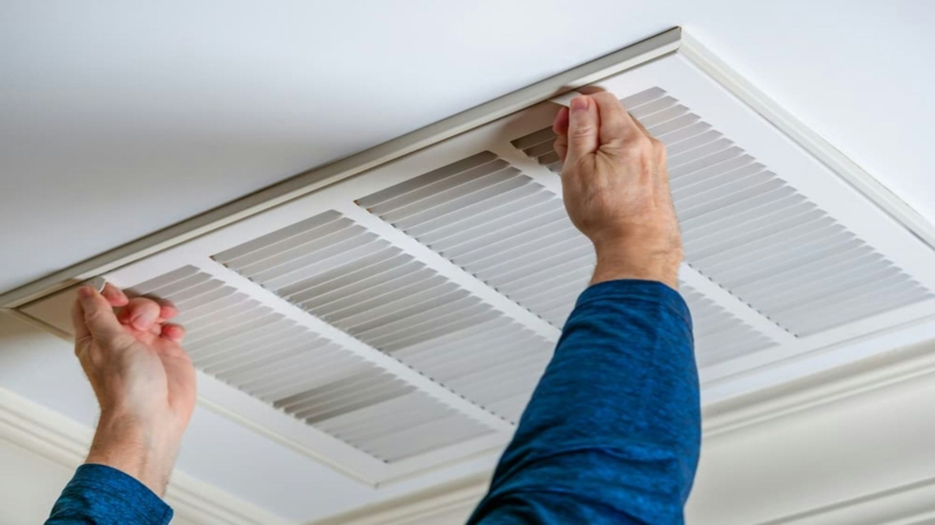 A person is working on a ceiling air conditioner